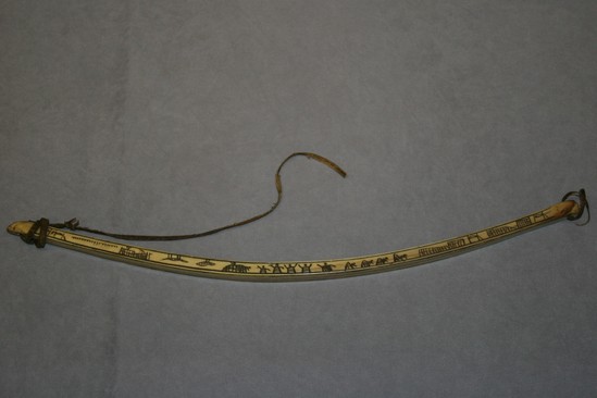 Hearst Museum object titled Bow, accession number 2-4119, described as Ivory bow for drill; incised and darkened scene one side only; rawhide thong.