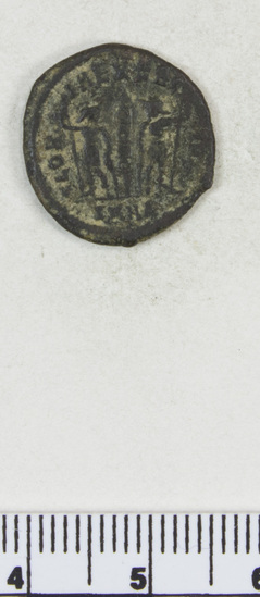 Hearst Museum object titled Coin: æ, accession number 8-6084, described as Coin: Æ; Constantine II - 1.75 grams. Obverse: illegible. Reverse: GLORIA EXER... - Standard between two soldiers I [over] SMNA (?).