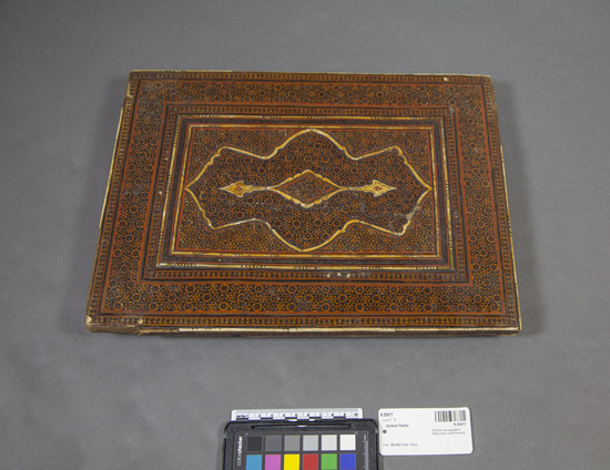 Hearst Museum object titled Picture frame, accession number 9-20411, described as Koran cover (?)/ table top (?), wood, rectangular; rectangular recess on one side; all sides covered with mosaic of wood silvers and bone or ivory in Khatam-kari style; length 36.5 centimeters x width 27.2 centimeters.