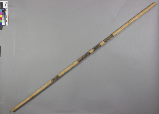 Hearst Museum object titled Walking stick, accession number 5-13123, described as OL., Kenya, Basuba, Boni. August, 1975. 5-13123, acc no. 3174. File code: 1.4 Collector: Jean Colvin. Donor: University appropriation. Materials, techniques: Carved with small knif. Some parts are darkened by fire. Owner carves his name at the top. Wood of DAN tree. Context of use: Made by and Used by Boni young men and boys. Used as a walking stick and to "make then attractive to women" Description: Walking/swagger stick- wood, long, narrow, cylindrical stick carved along its length with decorative designs and darkened in 4, 4.5 cm. areas. No decoration at either end. Name carved at top section AFUWAMMIA AZAMMIMIA. L. 78 cm x 1.5 cm.