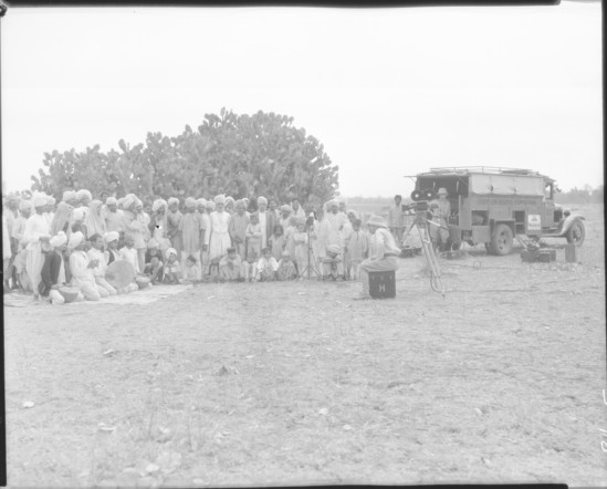 Hearst Museum object titled Black-and-white negative, accession number 15-30485, described as 8 x 10" Black and white negative of the Hoefler Asiatic Expedition filming a celebration.  Hoefler's original description: "Bhopal State, Central India. Near Camp Sultanpur. To the countrymen of India, who till the soil in a small way and possess a few head of cattle, goats and sheep, the depredations of marauding tigers constitute a real tragedy. When these blood-thirsty cats kill his work-oxen or wontingly destroy his flocks, it is a great loss that may take him years to redeem. In addition to these black marks against the tiger, the villager often finds it necessary to score against him a tragedy, for quite often the tiger becomes a man-killer, terrorizing whole districts until he is destroyed. No wonder then that when tigers are killed, these people get together and show their appreciation by celebrating with music and dancing. Photograph shows the Hoefler party filming such a celebration held after the killing of three tigers in one day near this Camp."  Verso: Prints Supplied To: Publicity Department.