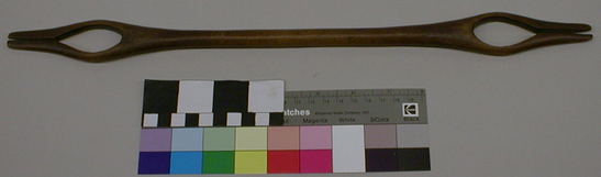 Hearst Museum object titled Shuttle, accession number 1-9484, described as Netting shuttle, wood, handcarved with oval opening and slot at each end.  Polished from use.