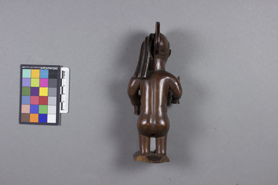 Hearst Museum object titled Figurine, accession number 5-5291, described as wooden male figurine with knife in right hand, knife sheath in left; inset shell eyes; elaborate scarification; on original square wooden base; height 16.5 cm