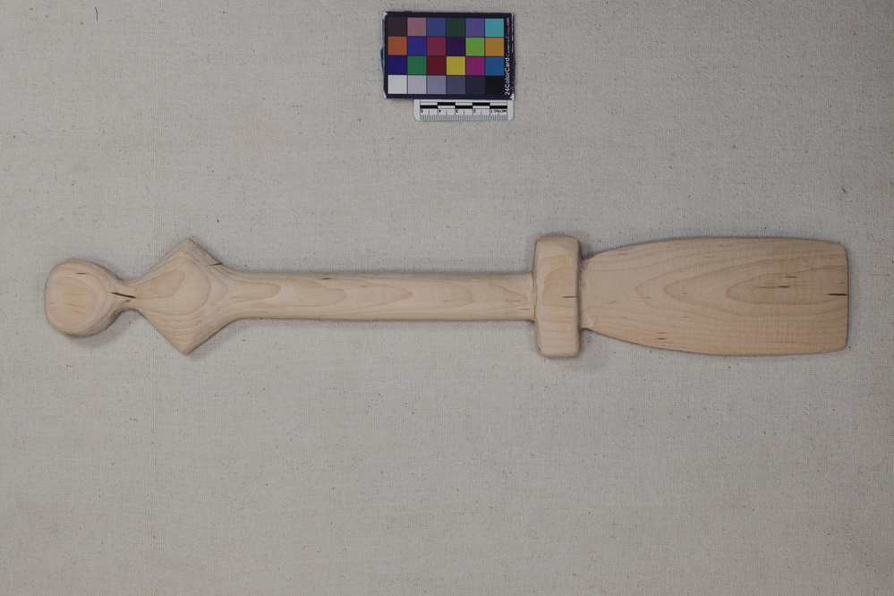 Hearst Museum object 2 of 3 titled Mush paddle, accession number 1-259281, described as Mush paddle, handle carved with diamond and circle shapes at top, and rectangular grip at paddle end.