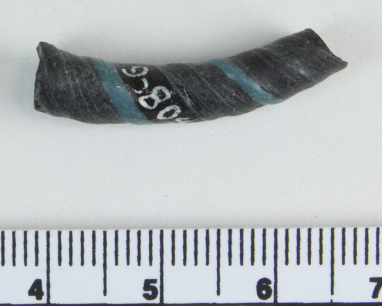 Hearst Museum object 2 of 6 titled Bracelet fragment, accession number 9-8049, described as Glass bracelet frag.; opaque black, twisted, curved rod w/ blue spiral; 27 x 7 mm.