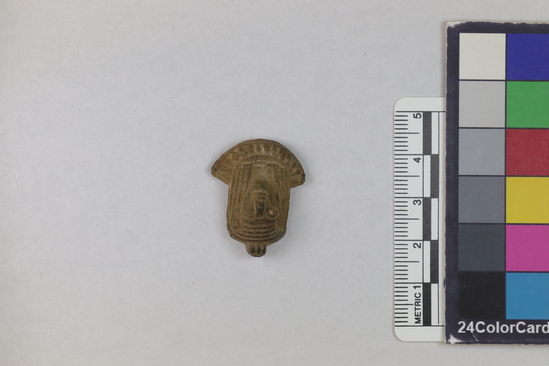 Hearst Museum object 10 of 11 titled Amulet, accession number 5-13917, described as Amulet: anthropomorphic with beadwork collar, long straight hair, bulging eyes, and ears high on head. No holes for stringing amulet. Maybe a fake. Fingerprint on back. Height 2.7 cm.