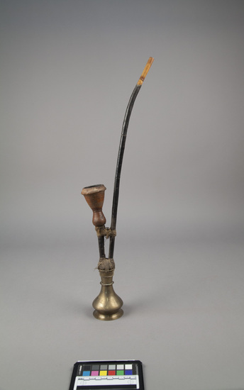 Hearst Museum object titled Smoking pipe, accession number 9-11507a-c, described as Pipe, water (hookah); small; brass base (a) with stem unit (b) (two stems, both straight - one for chilam and one for inhaling through) tied to the base; (c) chilam, unglazed ceramic.  A) and B): height. 59.3 cm: C) diameter: 5 cm.