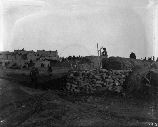 Hearst Museum object titled Black-and-white negative, accession number 15-280, described as Winner of the Antelope race coming in on the way to the Kiva, Snake priest following him; spectators in the background.