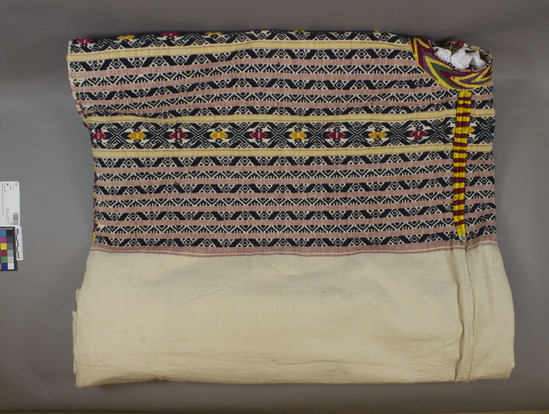Hearst Museum object 3 of 3 titled Huipil, accession number 3-69, described as Woman’s shirt or "guipil"; white cotton; basket weave; also yellow and red; brocaded dark blue cotton; red and yellow silk embroidery; purple, red, green and yellow silk; embroidery around neck; approximately 1 m 19 cm wide 1 m 6 cm long; Red silk floss is cochineal (see letter in acc. env.)