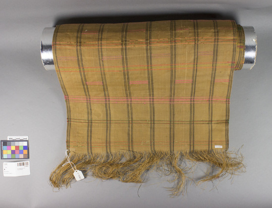 Hearst Museum object titled Mat, accession number 11-42805, described as Fiber strip, woven, black, pink, green, yellow, orange plaid pattern, tan background; stained and worn. 160.0 cm. x 44.0 cm.