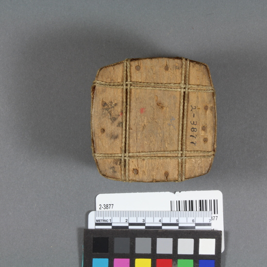 Hearst Museum object titled Box, accession number 2-3877, described as Small, cube-shaped, wooden box  with fitted lid and decorated with geometric patters in red. Red edges on box and red triangles on cover. Bound with strings. Bentwood.