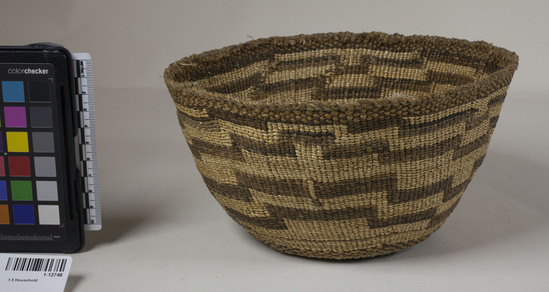 Hearst Museum object 2 of 2 titled Cooking basket, accession number 1-12746, described as Cooking basket; twined. Warp is twisted Tule (Schoenoplectus acutus), weft is twisted Tule and Nettle (Urtica) string. White pattern is Reed (Phragmites vulgaris). Red dye is Tule root. White dye is twisted Cattail (Typha latifolia). Brown color is mud-dyed Tule skin. horizontal figure. Nettle string rim. Indigenous name: maksha.