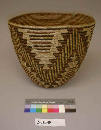 Hearst Museum object titled Bowl basket, accession number 2-10300, described as Slightly oval, deep, coiled basketry bowl. Black, brown, and yellow decoration arranged over whole surface of basket in zag-zag fashion.