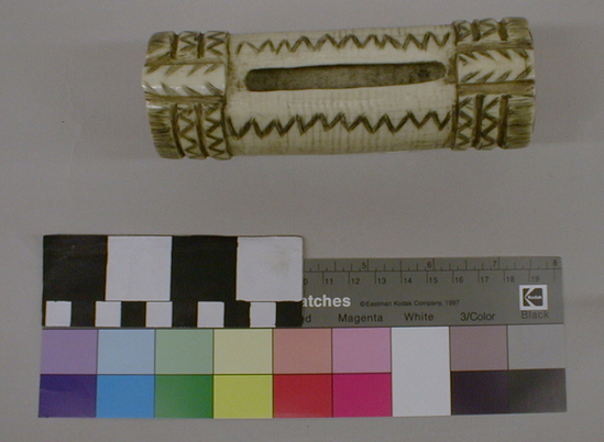 Hearst Museum object titled Money purse, accession number 1-255013, described as Elk horn. Off-white color with zigzag and saw tooth design on it. The ends are red.