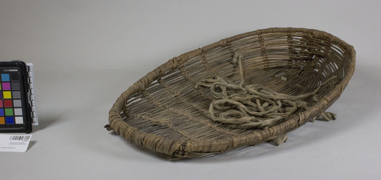 Hearst Museum object 2 of 2 titled Cradle basket, accession number 1-27941, described as Fragile. Dirty and worn from use. Oval shape. Twined openwork. Groups of 2 rows slanted opposite directions. Hoop rim of shoots sewn together. Ties of white cotton fabric.