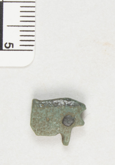 Hearst Museum object titled Amulet, accession number 5-13983, described as Amulet: uzat eye, blue with black pupil and eyebrow. Surface covered with brown film. Holes through ends. Pock marks in surface of glaze.