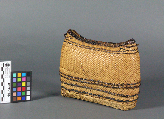 Hearst Museum object titled Basket, accession number 10-3438, described as Bag; tan, bamboo plaited ovoid shaped bag made up of four nested baskets ;18 cm top to bottom; 28 cm w., 5.5 cm deep when assembled; a) top ;ovoid shape basket with concave (saddled-shaped) closed top; plaited bamboo with dark brown horizontal elements at lower (open)edge and band of braided multi shaded brown elements embelishing saddle shaped top, 2 loops for carrying strap (missing) b and c)  same with horizontal rows of two braided dark brown horizontal elements ;each has a recessed , curved interior which allows them to be  nested inside one another without appearing to be so from outside; d) same as b and c, but with flat bottom with 2 cm braided tan strip surrounding.  Each basket has slightly smaller guage of split bamboo and slightly larger circumference to accommodate nesting.