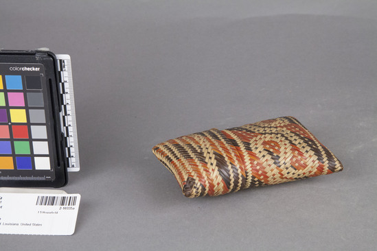 Hearst Museum object titled Covered pouch, accession number 2-10335a,b, described as Covered pouch made of split cane with red and black decorations.