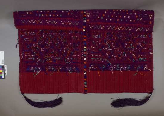 Hearst Museum object titled Tzute, accession number 3-23459, described as Man’s tzute (shawl?); red cotton warp face; thin blue warp stripes, 2 widths; heavy varicolored silk brocade center; main color is purple, seamed in silk blocks of same colors with purple tassels at each corner.  “New style.”