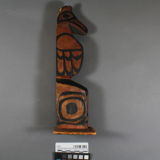 Hearst Museum object 3 of 4 titled Totem pole model, accession number 2-41024, described as Wooden totem pole model, carved and painted, on wooden base; upper half, which probably represents a raven, has carved head, black-painted details. Old label says "Kitkatlah, B.C.".