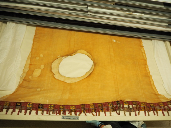 Hearst Museum object titled Poncho, accession number 16-1081, described as Filmy yellow poucho with red, black, and white tapestry border and fringe ornamented with bird designs