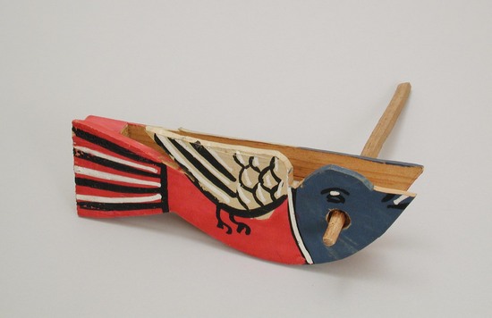 Hearst Museum object titled Noisemaker, accession number 3-28958a,b, described as Toys.  Noisemakers, wood, crudely made; thin wood blade hits wood rachette when noisemaker is twirled on handle.  (a) bird shape, brightly painted, L 18 cm;  (b) painted red and white with paper pictures pasted on top, L 17.5 cm