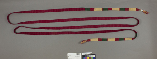 Hearst Museum object 2 of 2 titled Cinta, accession number 3-86, described as Woman’s headband or cinta; twilled wool and cotton; red with green and off-white portions; approximately 3 m 26 cm, 1.6 cm wide