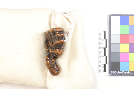 Hearst Museum object 12 of 12 titled Netsuke, accession number 9-18836, described as Netsuke; Fukurojoku and attendant; God with elongated head and small monkey (?) at his right side; smiling (?) face; possible seal in base; H 5.1 cm X W 3.5 cm