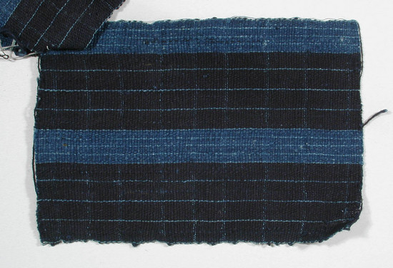 Hearst Museum object titled Textile fragment, accession number 5-11074, described as Textile sample (section of narrow band weaving): Navy ground divided by both horizontal and vertical stripes of pale blue (very narrow) and two bright blue stripes, also divided by pale blue lines.