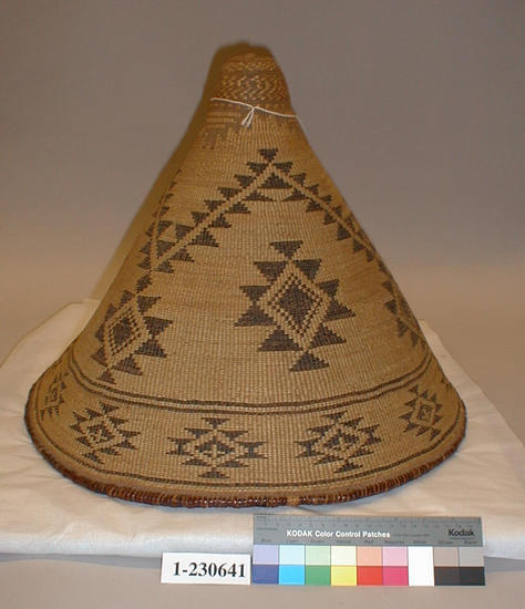 Hearst Museum object titled Basket, accession number 1-230641, described as Plain twined, conical shape with stick rim, black designs of horizontal zigzags and serrated diamonds on ground of beargrass overlay. Willow (?) shoot warp, pine root weft.  Overlay in Xerophyllum tenax and fern stem, adiantum pedatum.