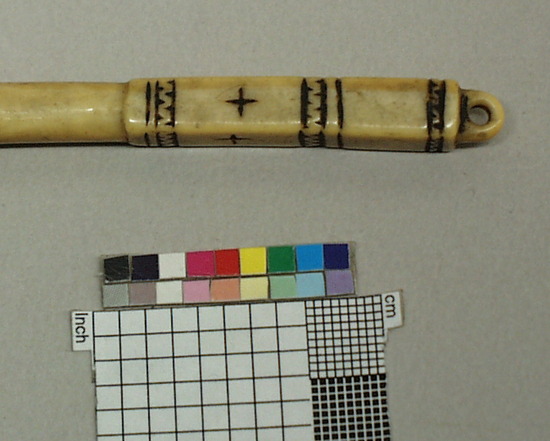 Hearst Museum object 4 of 4 titled Awl, accession number 2-4148, described as (Bodkin), ivory, encircling zigzag bands, suspension hole at top.