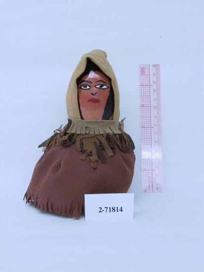 Hearst Museum object titled Female doll, accession number 2-71814, described as Pamunkey gourd female doll.  Painted hair and features.  Dressed in a hooded, shoulder cape of canvas and cotton fabric, and “skirt” of brown knit material. Height 6.0 inches