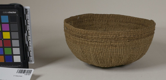 Hearst Museum object 2 of 2 titled Basketry cap, accession number 1-87101, described as Work cap. Maily plain twining. 3 strand twining continues from start to where the first zone divider of 3 strand would normally occur. Two encircling bands of yellowish white overlay 4 cm. from start. Near rim is extra single row of 3 strand twining. Plain twining.  Conifer root, white grass.