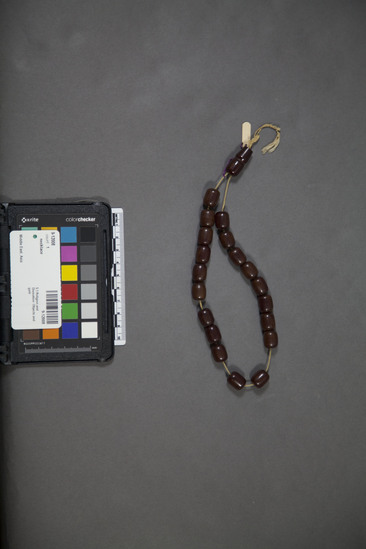 Hearst Museum object titled Necklace, accession number 9-12008, described as Worry beads, reddish brown plastic; 1 double, 19 single beads on cotton string; object to fiddle with when worried