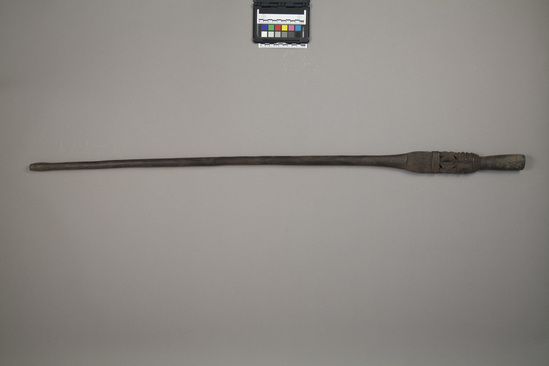 Hearst Museum object titled Walking stick, accession number 11-39821, described as Sparring club/ walking stick/ swagger stick of black wood decorated with incised patterns on upper end. End with handle and double squatting figure decoration. 108.5 cm length