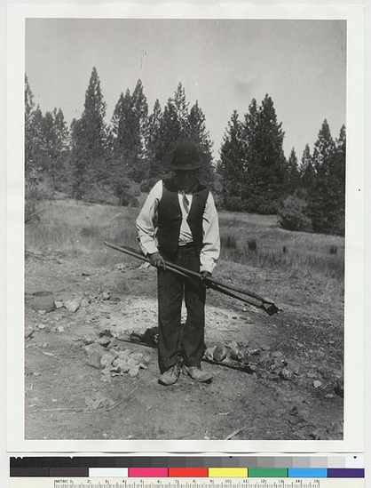 Hearst Museum object titled Black-and-white negative, accession number 15-2739, described as Old Pedro illustrating the handling of hot rocks with wooden tongs in cooking acorn soup and bread