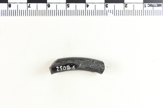 Hearst Museum object 6 of 6 titled Bracelet fragment, accession number 9-8032, described as Glass bracelet frag.; opaque black, twisted curved rod; 18 x 7 mm.