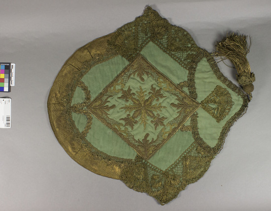 Hearst Museum object titled Textile, accession number 7-6893, described as Shaped piece.  Various kinds of metal yarns.  Lace, ribbon, embroidery, tassel.  Green and gold.  16½ inches by 17 inches.