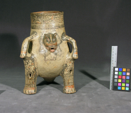 Hearst Museum object titled Effigy bowl, accession number 3-26773, described as Effigy bowl; polychrome tripod rattle effigy bowl with modeled jaguar head, two vertical strap handles formed by front paws, modeled tail. 26.7 cm high.