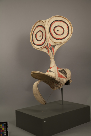 Hearst Museum object titled Mask, accession number 11-40748, described as Mask, kavat-style; tapa with red and black painted designs over wood framework; headpiece has bill-like extension in front, tongue-like extension below bill, large upward extension with painted face having prominent eyes; said by dealer to be fire dance mask.