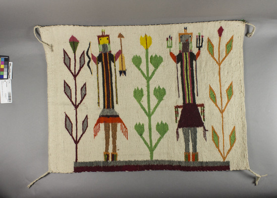 Hearst Museum object 2 of 2 titled Wall hanging, accession number 2-17191, described as Small, white blanket.  "Yei" throw with 2 figures, 3 corn plants; multicolor analine dyes on white ground.