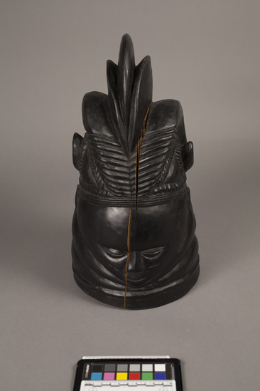 Hearst Museum object 2 of 4 titled Helmet mask, accession number 5-5833, described as helmet mask of West African gum wood blackened with shoe polish; anthromorphic with elaborate headdress and horns; split in center of face. height 37 cm.