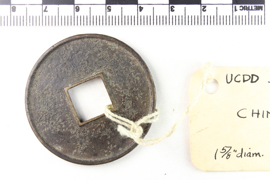 Hearst Museum object titled Coin, accession number 9-13378, described as Coin, bronze. Round with square center hole. Center hold and sides have raised edges. Size: 4 cm diameter. Obverse description: Four characters and green  patina. Reverse Description: Green patina. No design.
