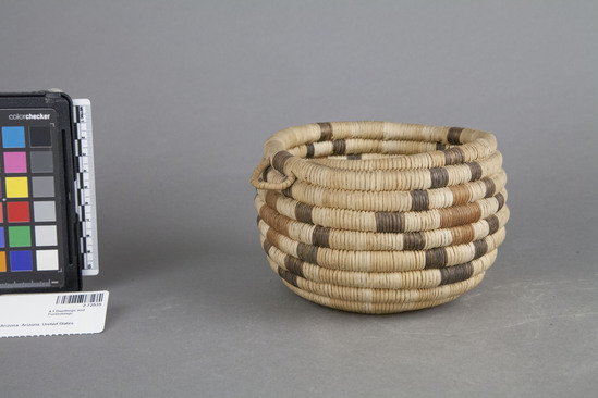 Hearst Museum object titled Basket, accession number 2-72535, described as Round, woven, coiled, basket with diamond designs (black & sepia) on 4 sides and small loop handles on two sides. Body of basket is natural willow, black is devil's claw, red is?.