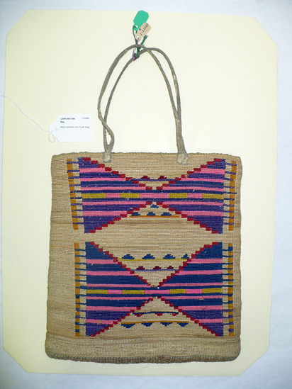 Hearst Museum object 3 of 8 titled Bag, accession number 2-22260, described as Multi-colored corn husk bag; cornhusk and wool overlay in plain twining; geometric designs in colored wool yarn on both faces; 2 rawhide thong handles.