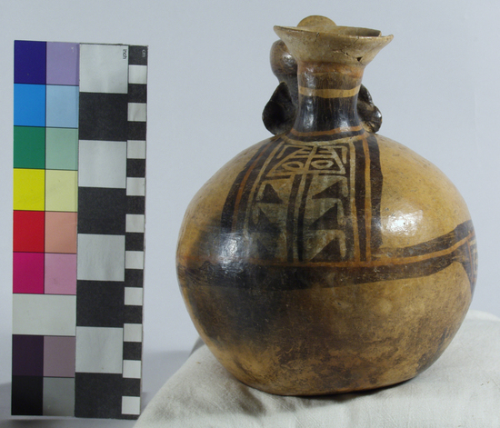 Hearst Museum object 12 of 13 titled Bottle, accession number 16-12115, described as Pottery bottle with flaring spout; effigy of a man with a turban with small spout in front; red and buff slip and resist painted designs; height: 19 cm. Has been waxed. See over.