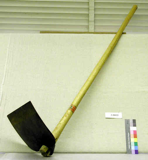 Hearst Museum object titled Hoe, accession number 3-30133TMP1, described as Broad Hoe, Mattock Date “4 Dec 1973” written in ink on handle; manufacturer’s label attached to handle and reads “ 'Papagayo’ from Temper Corporation out of Cleveland, OH.” Handle: 126 cms L x 13.5cms in circumference Hoe Blade:  30cms L x 30cms W