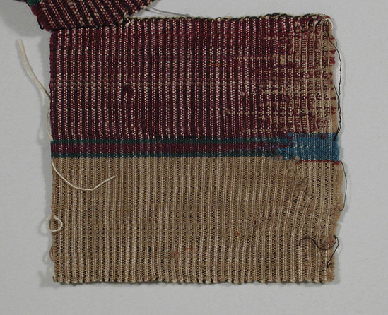 Hearst Museum object titled Textile fragment, accession number 5-11053, described as Textile sample (section of narrow band weaving): Left maroon, right tan; central stripe of meroon flanked by green becomes blue at lower edge.