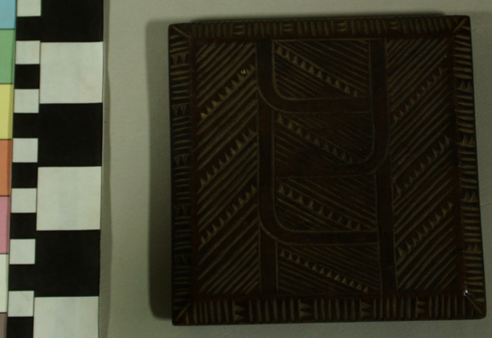 Hearst Museum object 2 of 8 titled Carved wooden box, accession number 11-42799a,b, described as Box and lid, wood, carved in relief, geometric pattern on lid and two sides of box, facial image carved on other two sides of box; tan and brown.