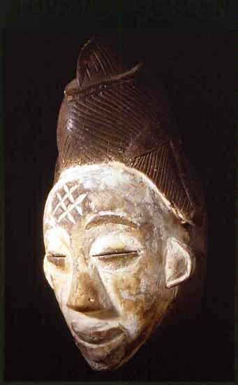 Hearst Museum object 2 of 2 titled Mask, accession number 5-15786, described as Mask, wood, handcarved; oval face, with slit eyes; averted lips; crossed diagonal lines incised on forehead; hair dressing incised; whitened face offset by brown on remaining surfaces; Length: 33 cm, Width/breadth: 18.5 cm